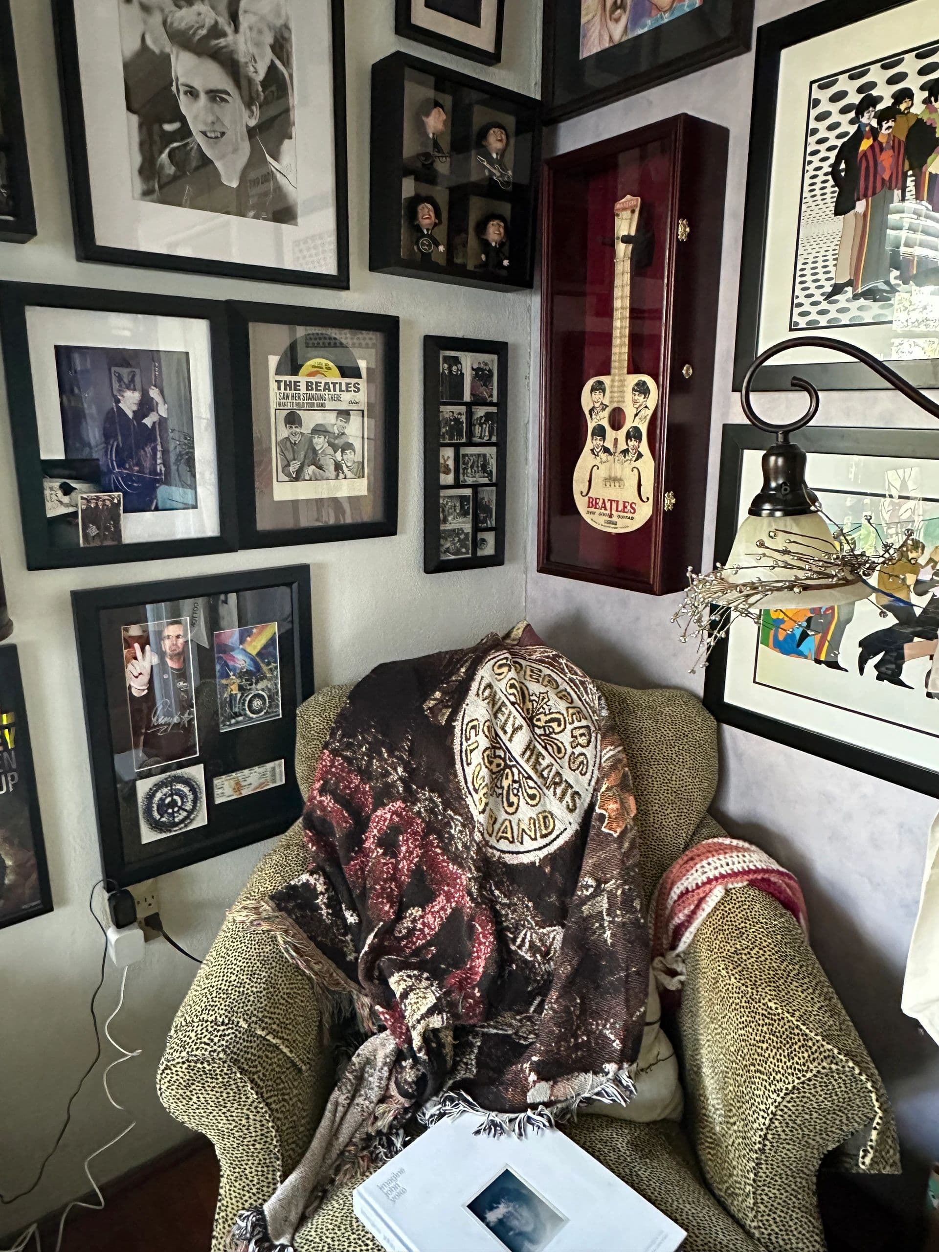 An easy chair beneath a wall of framed Beatles pictures, from The Beatle Room